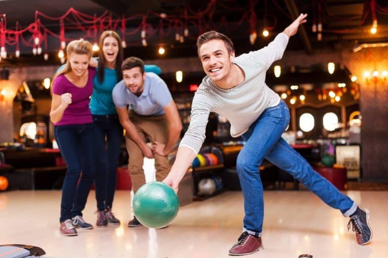 group-of-friends-bowling-cheering-at-alley-action-photo-homepage