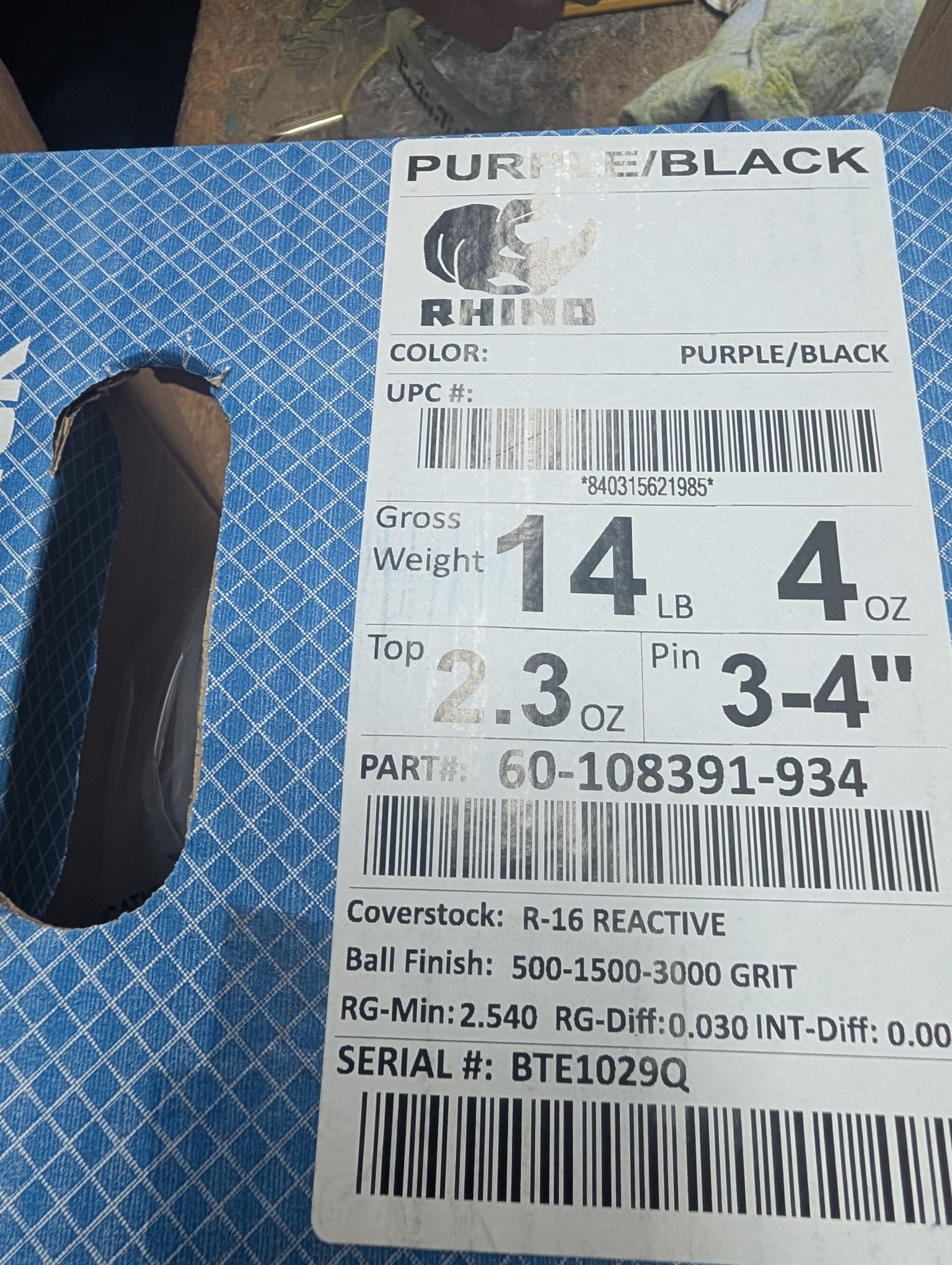 Brunswick Rhino Purple/Black bowling ball box label showing 14 lb 4 oz weight, R-16 Reactive coverstock, RG-Min 2.540, RG-Diff 0.030, pin 3-4 inches
