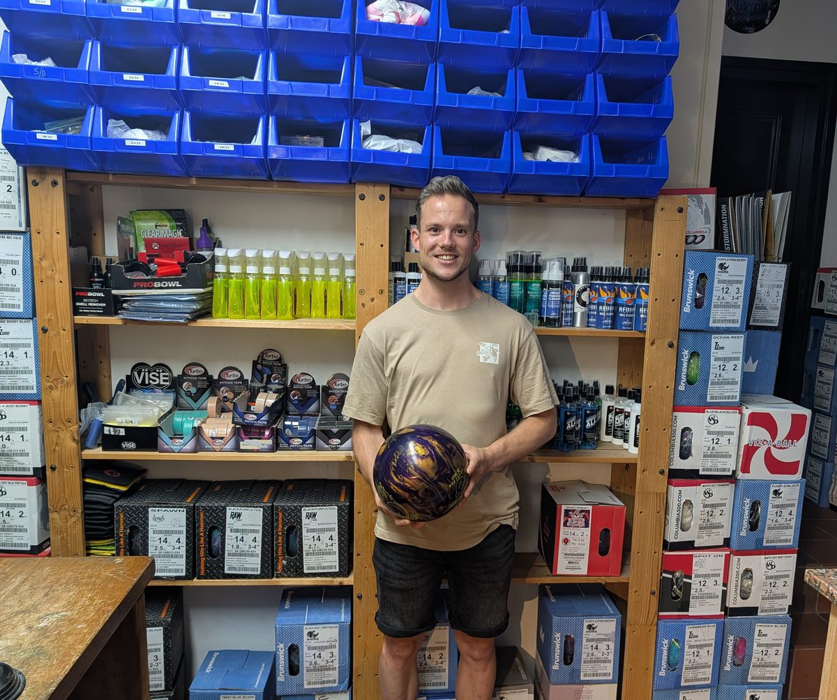 Jeroen Kooij, editor of ExpertBowler, holding his newly drilled purple and gold Ebonite Fireball bowling ball inside a pro shop